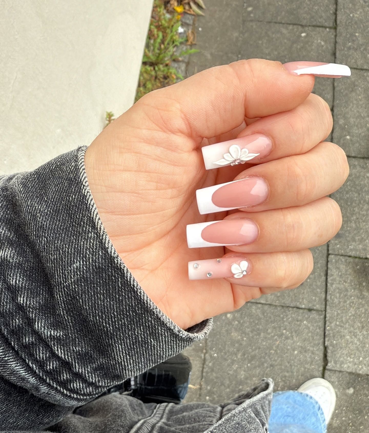Lange eckige Nägel mit French in Weiß und einer 3D-Blüte auf dem Ringfinger
